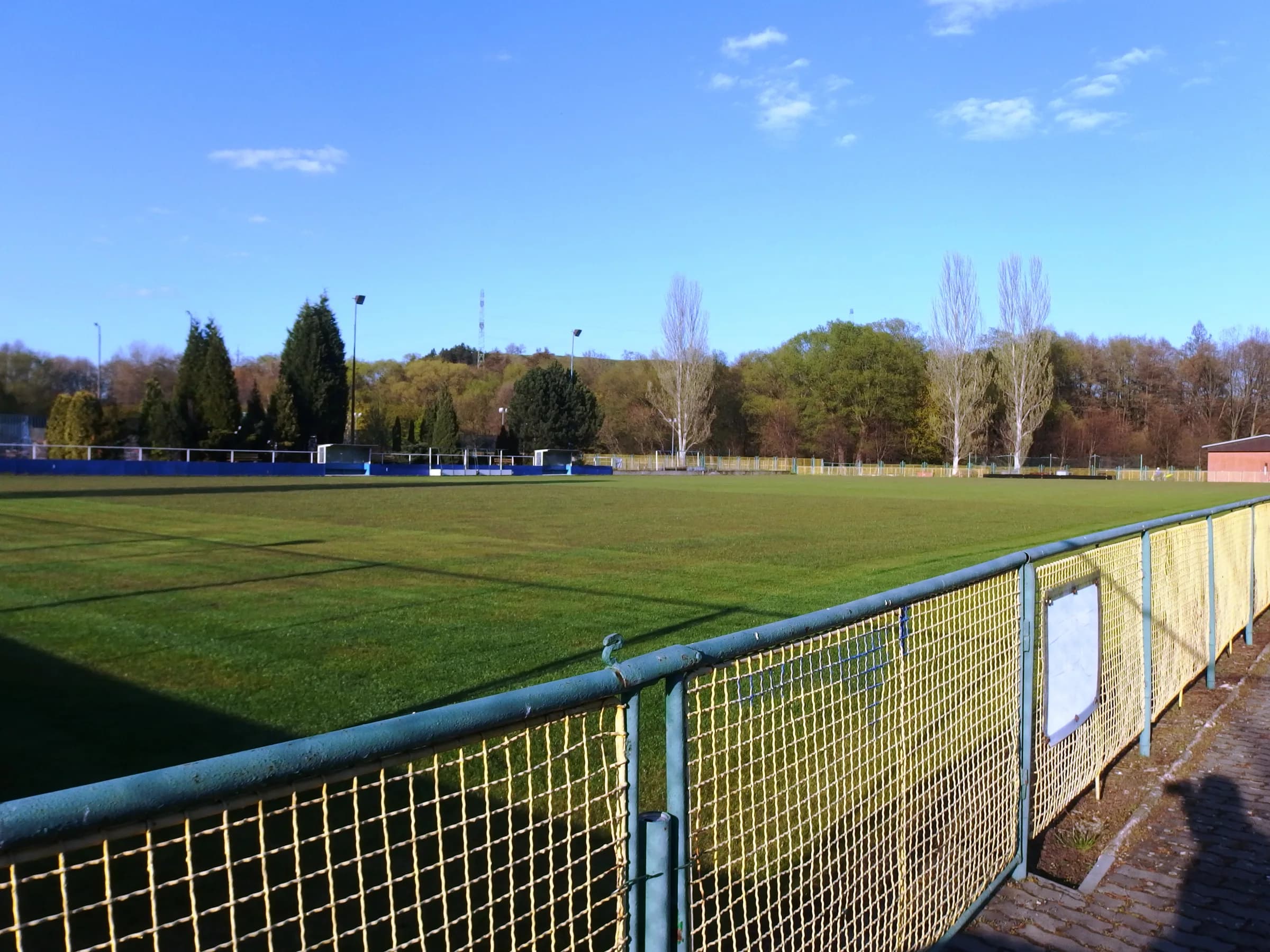 The outdoor field hockey pitch in Kadaň, Czech Republic, with trees beyond the playing surface.